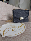 Bolsa crossbody Guess negra con monograma y cadena dorada