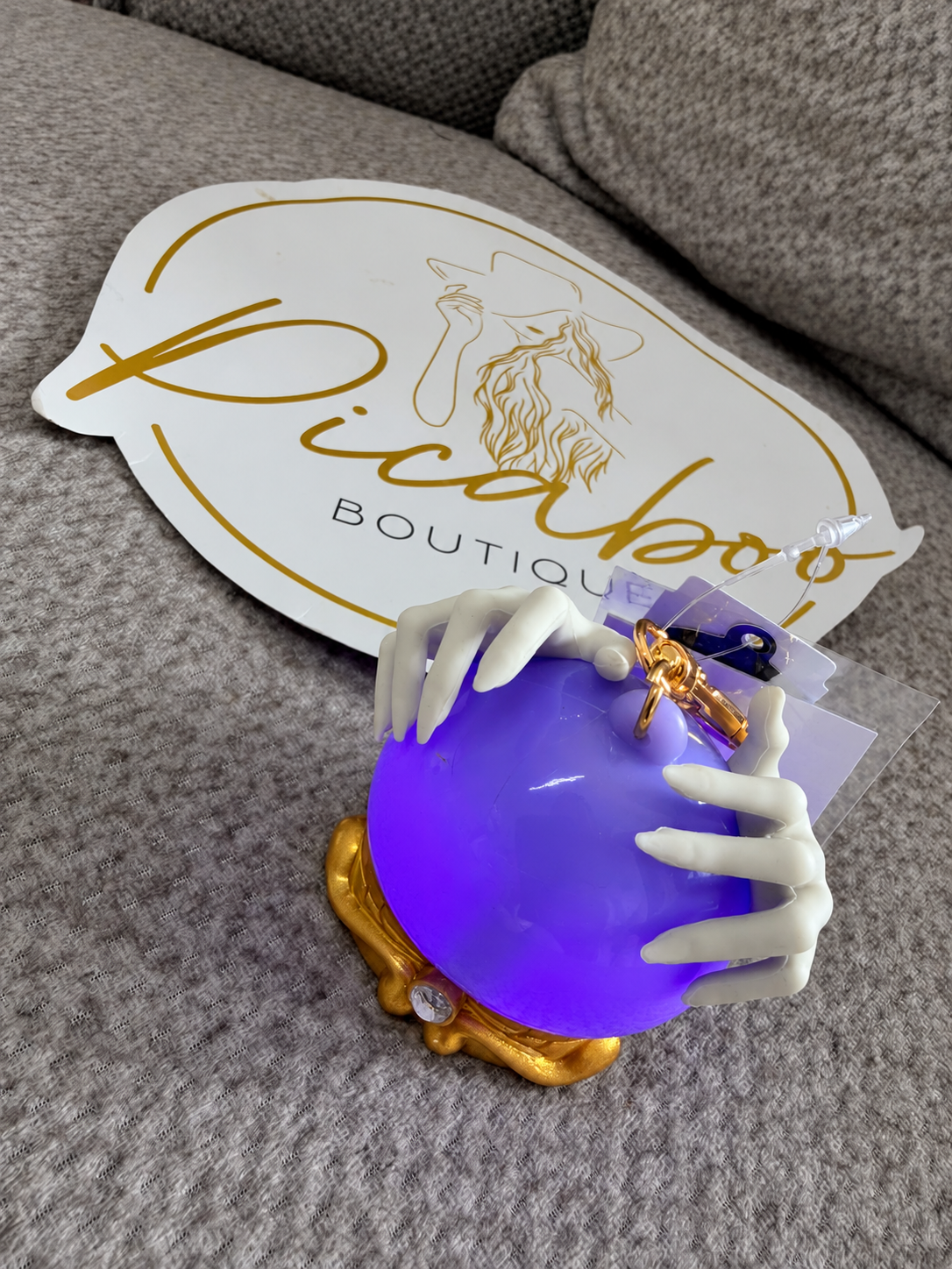 Porta gel esfera morada con manos de esqueleto y luz