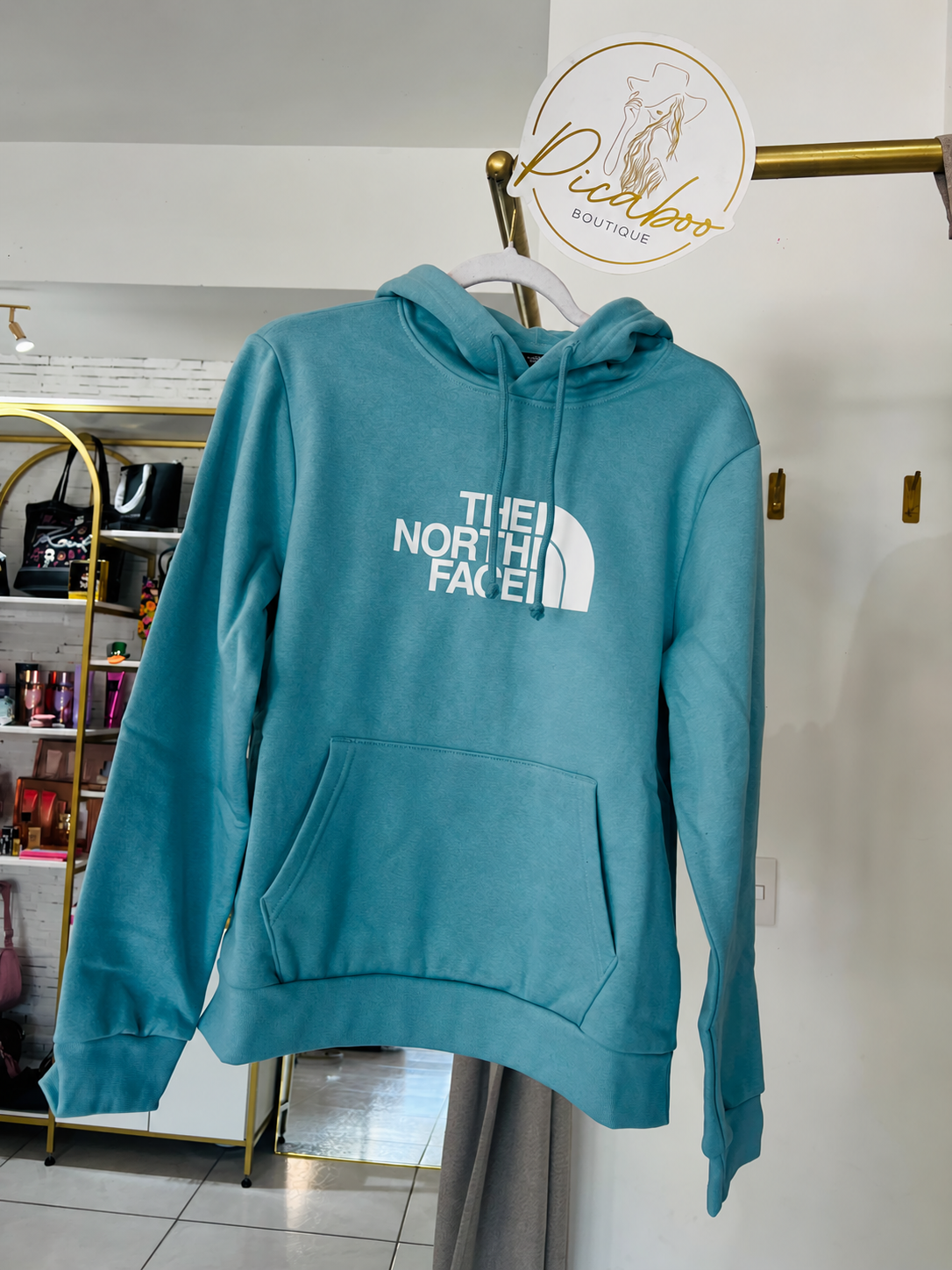 Sudadera The North Face turquesa con capucha y logotipo blanco